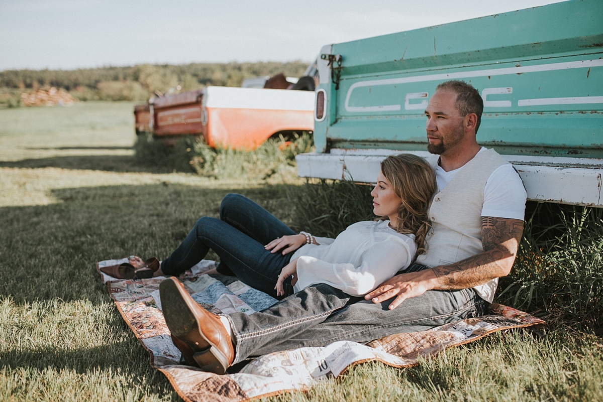 Engaged couple in front of an old GMC pickup on a farm in Edmonton, Alberta-Raelene Schulmeister Photography