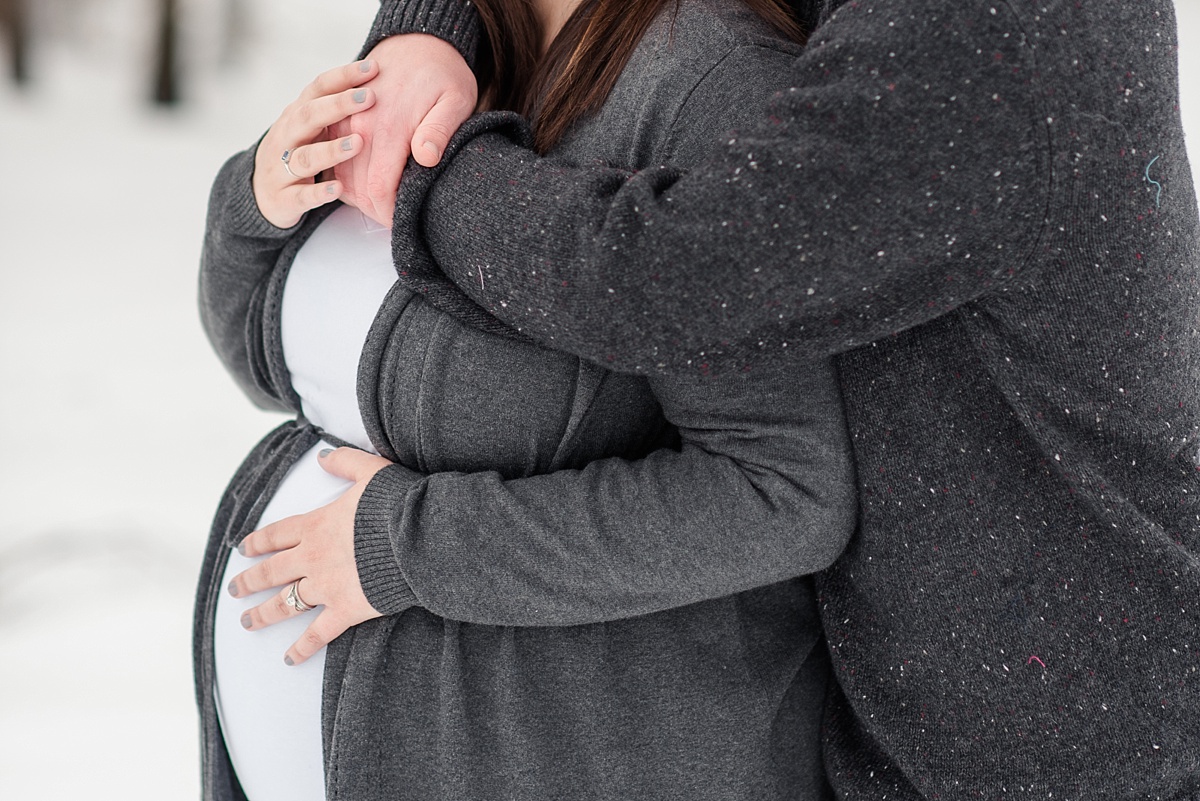 Winter Maternity photos - red deer photographers - husband holding onto wife - belly